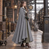 Manteau cape vintage gris porte de profil sur un quai de gare steampunk