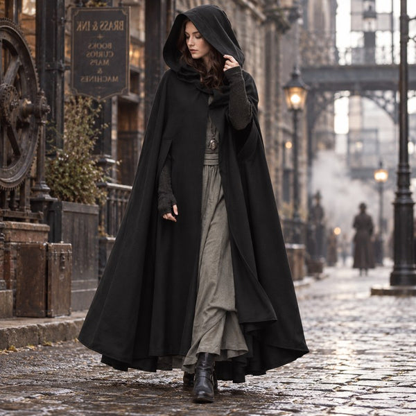 Femme portant le manteau cape vintage noir, capuche relevee, rue pavee steampunk