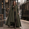 Manteau cape vintage vert kaki porte dans une gare steampunk